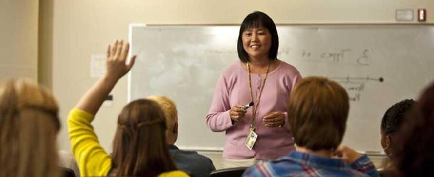 Student raising hand in classroom.